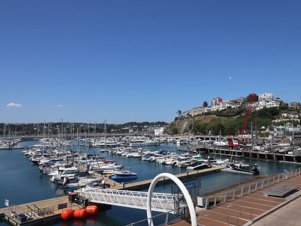 A marina with boats and a ferris wheel at Flat 2 The Moorings in Torquay