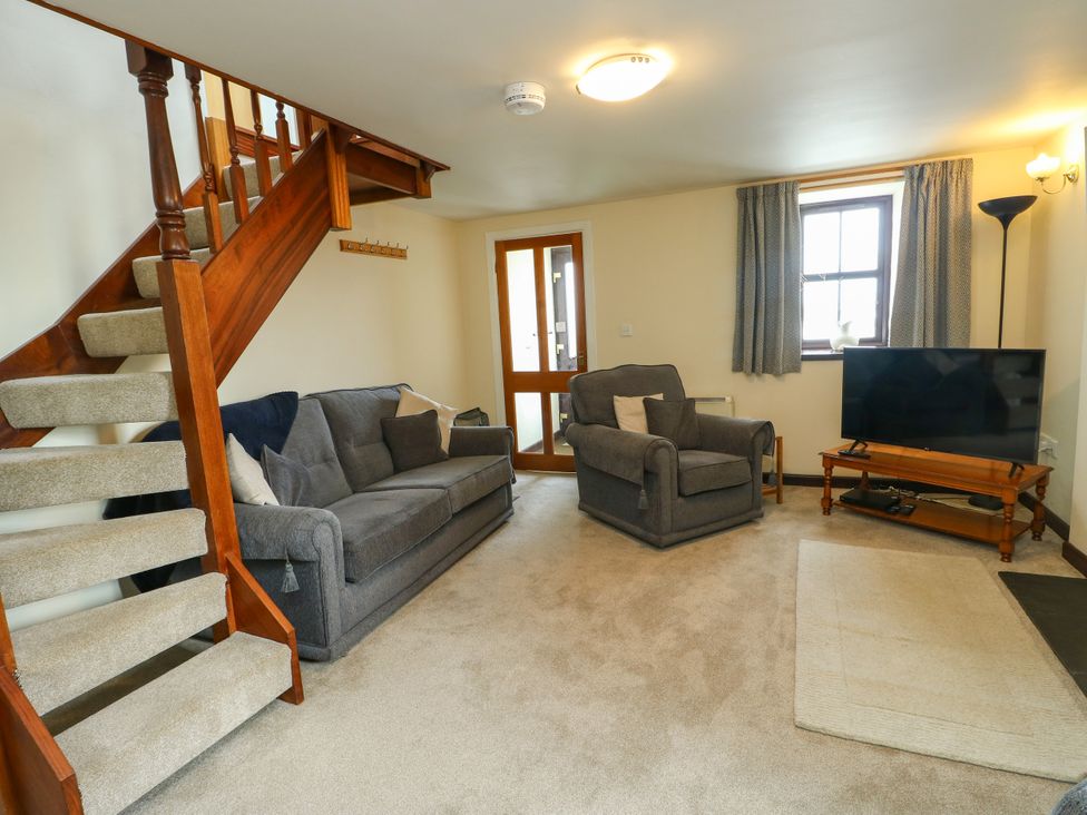 A living room with a sofa and armchair at Getws in Ty Croes