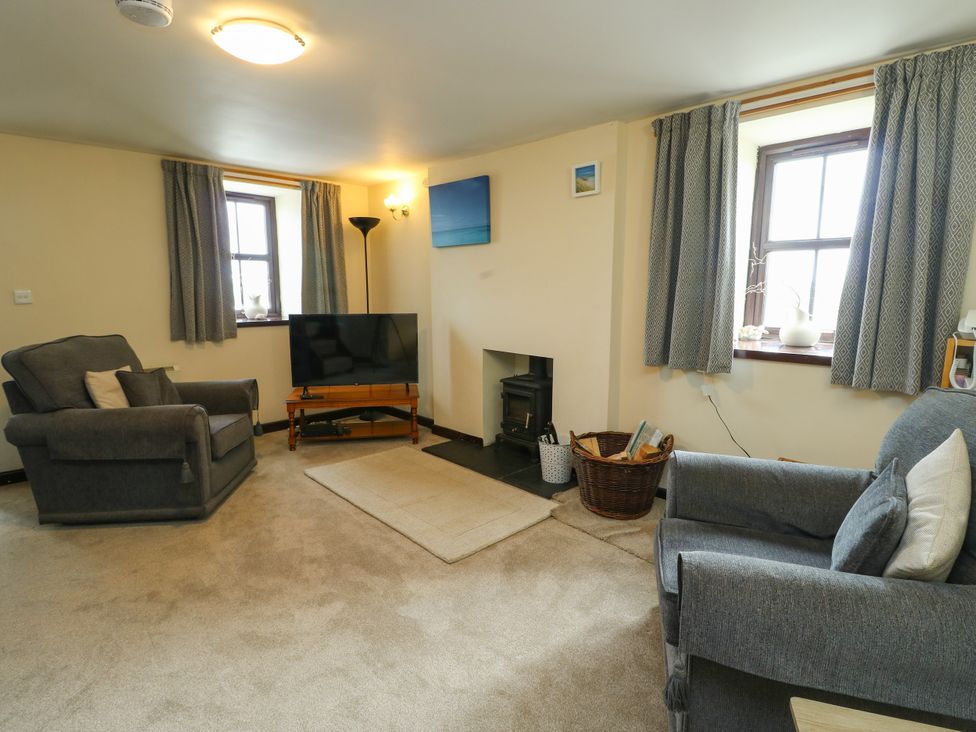 A living room with a sofa and television at Getws in Ty Croes