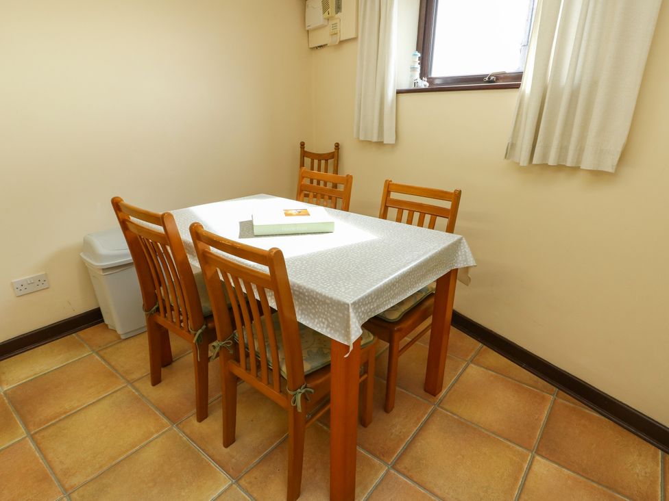 A dining room with a table and four chairs at Getws in Ty Croes