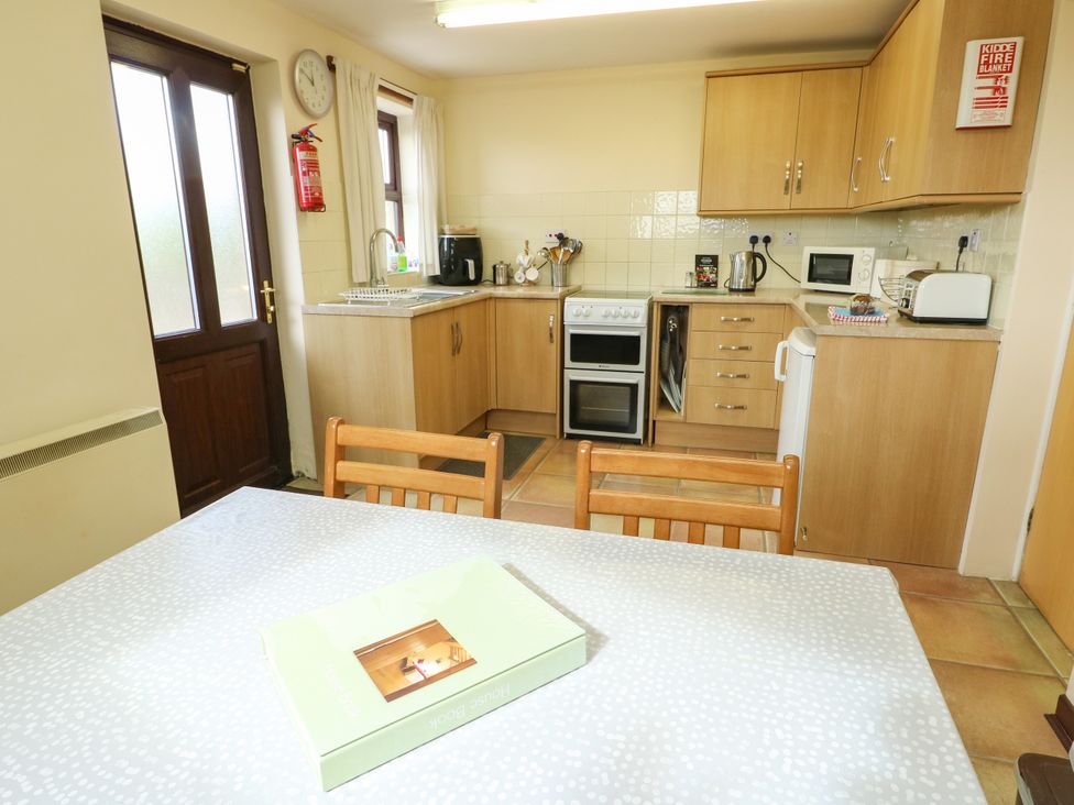 A kitchen with cabinets and appliances at Getws Ty Croes
