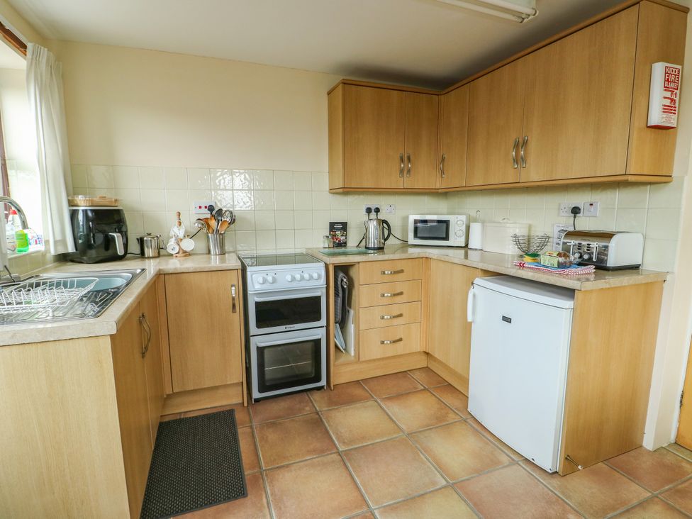 A kitchen with cabinets and appliances at Getws Ty Croes