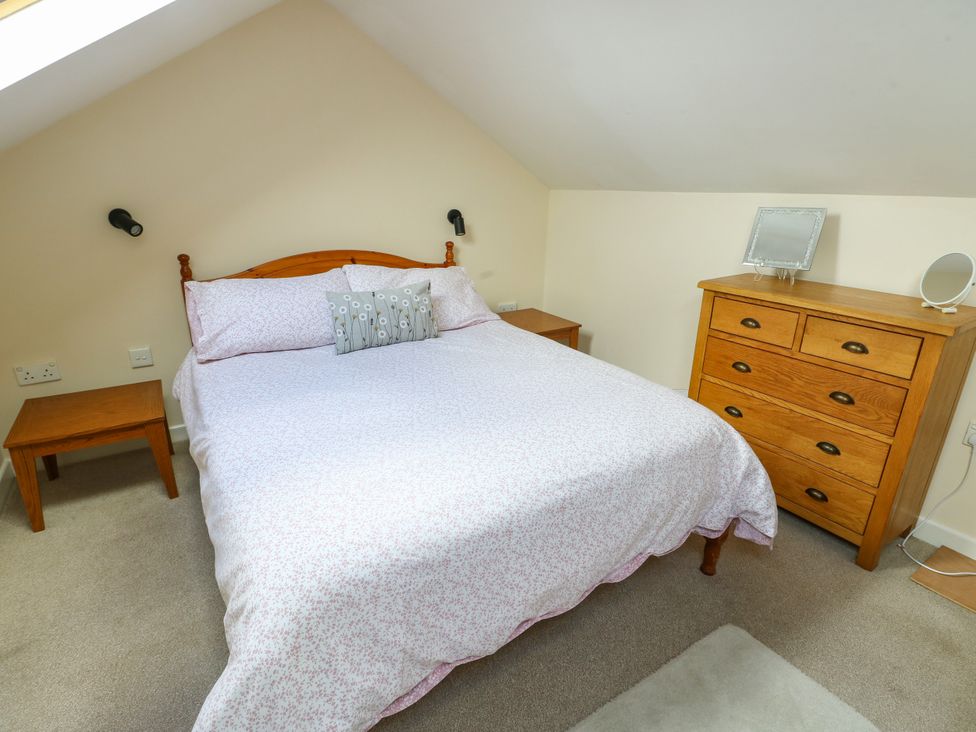 A bedroom with a bed and dresser at Getws in Ty Croes
