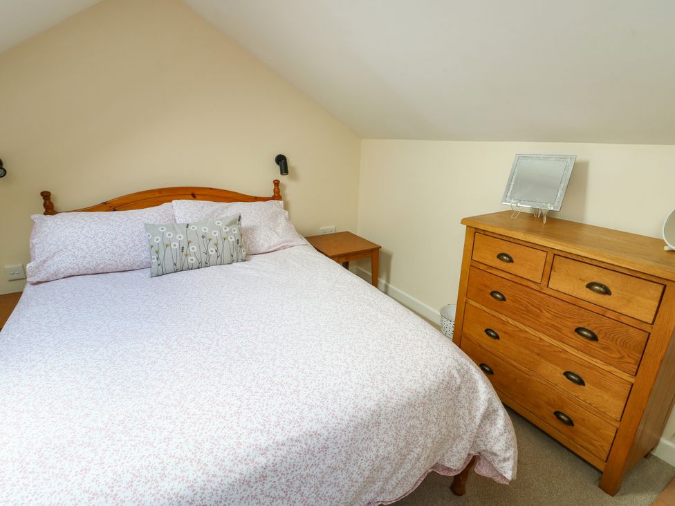 A bedroom with a bed and dresser at Getws in Ty Croes