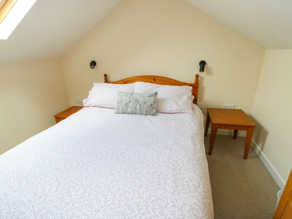 A bedroom with a bed and bedside table at Getws in Ty Croes