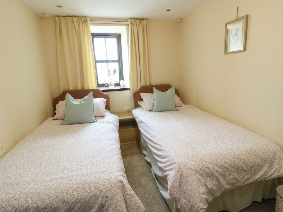 A bedroom with two single beds and a window at Getws in Ty Croes