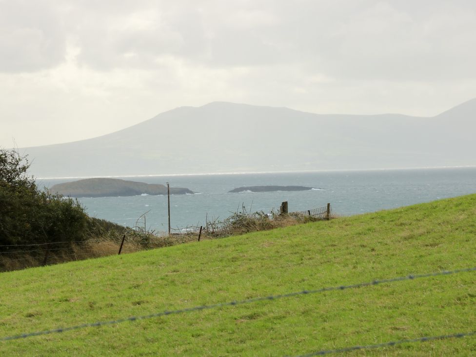 A view of islands in the sea with a mountain in the background at Getws, Ty Croes