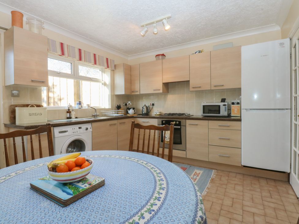 A kitchen with wooden cabinets and a dining table at 15 Rose Hill Beaumaris