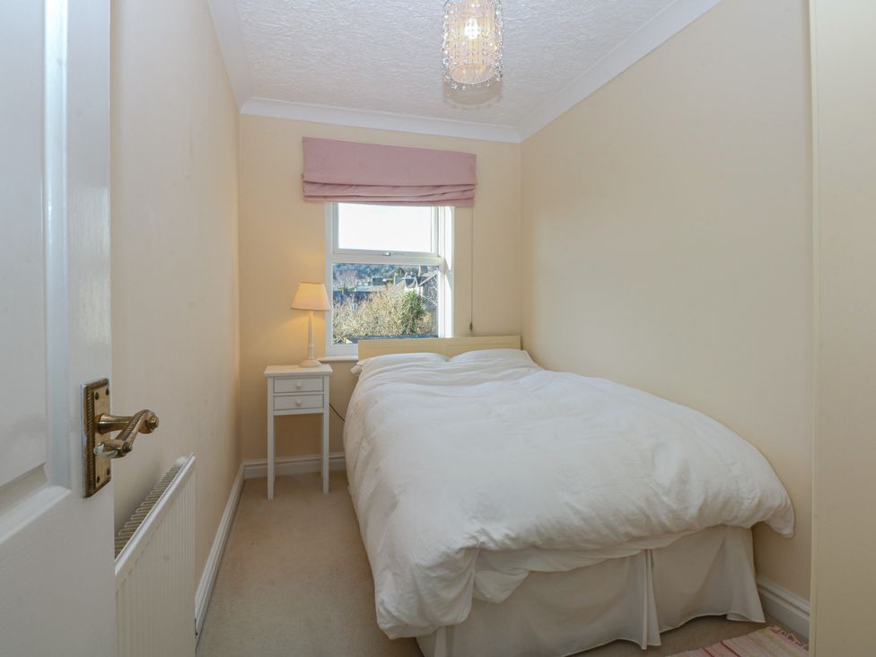 A bedroom with a bed and side table at 15 Rose Hill Beaumaris