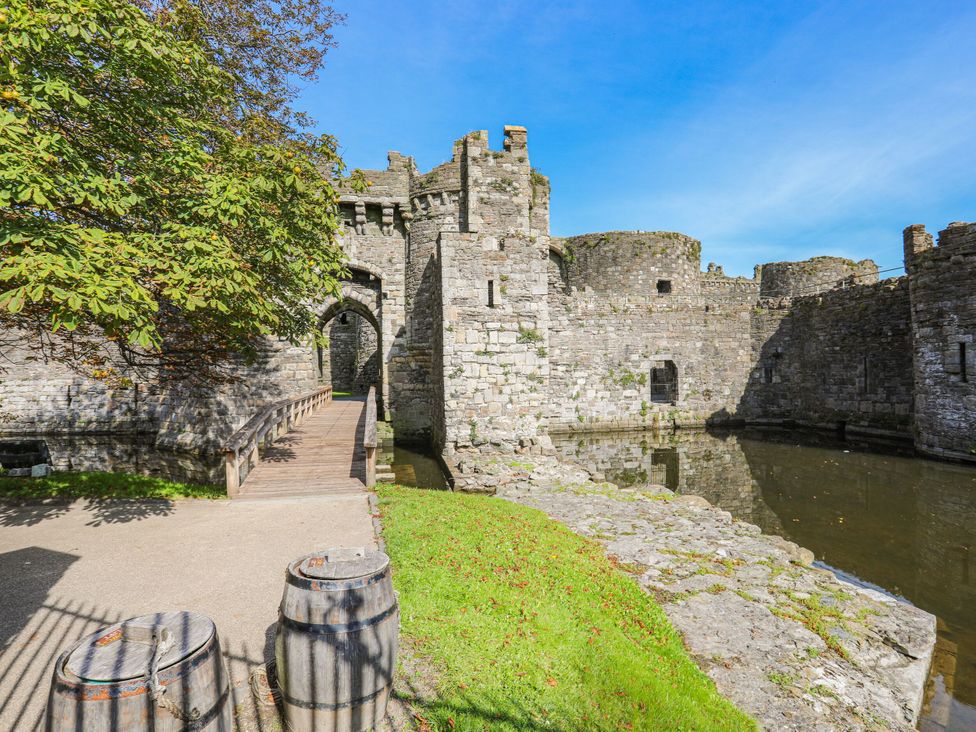 A castle with a bridge and water at 15 Rose Hill Beaumaris