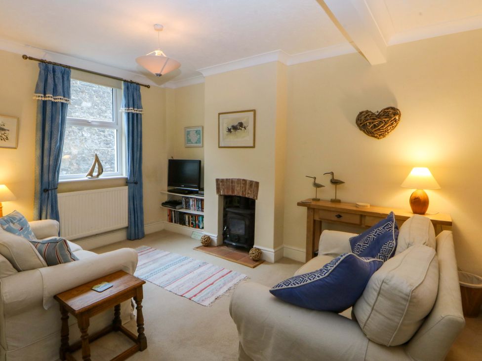 A living room with a sofa, fireplace and television at 15 Rose Hill Beaumaris