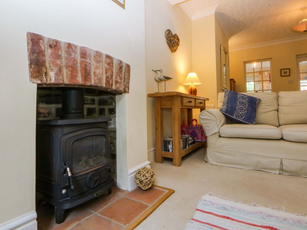 A living room with a wood stove and sofa at 15 Rose Hill Beaumaris
