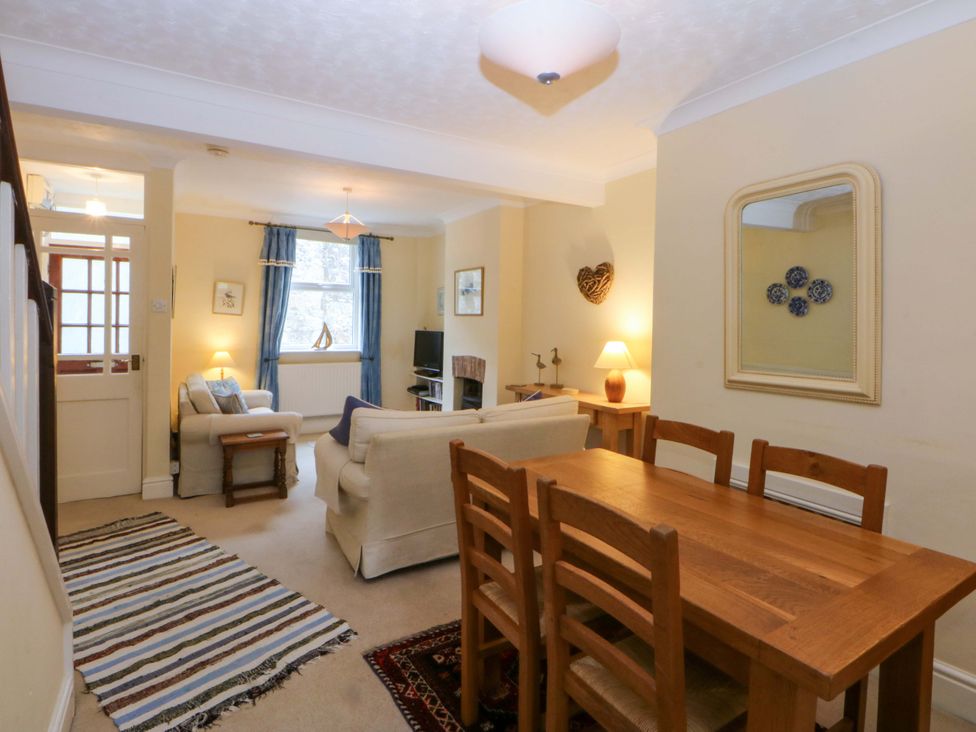 A living room with a sofa, table, and television at 15 Rose Hill in Beaumaris