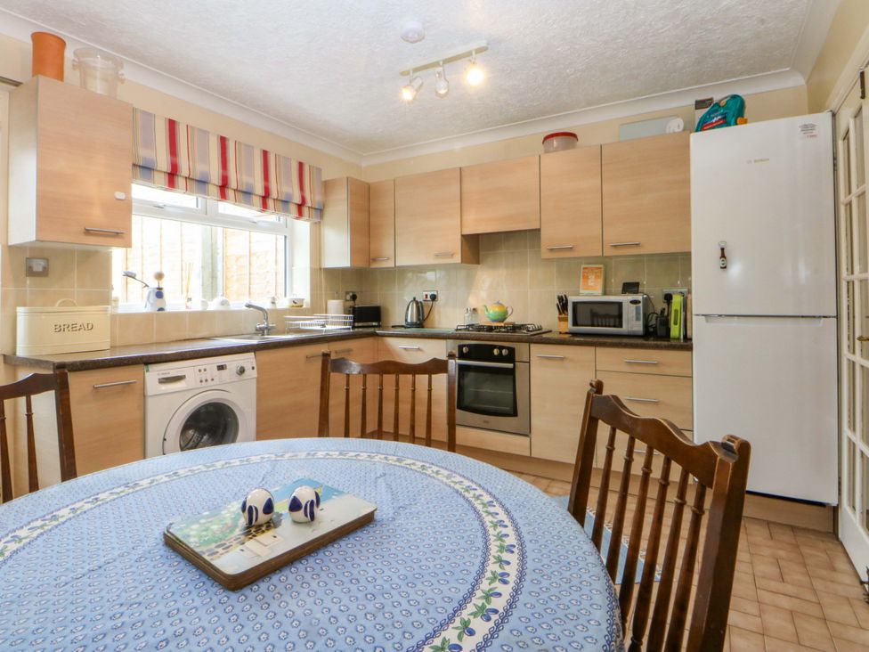 A kitchen with appliances and a dining table at 15 Rose Hill Beaumaris