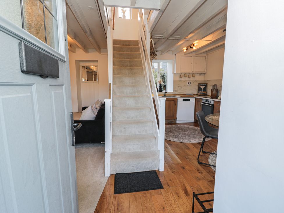 A hallway with stairs and a view of the kitchen at Lon Popty in Dolgellau