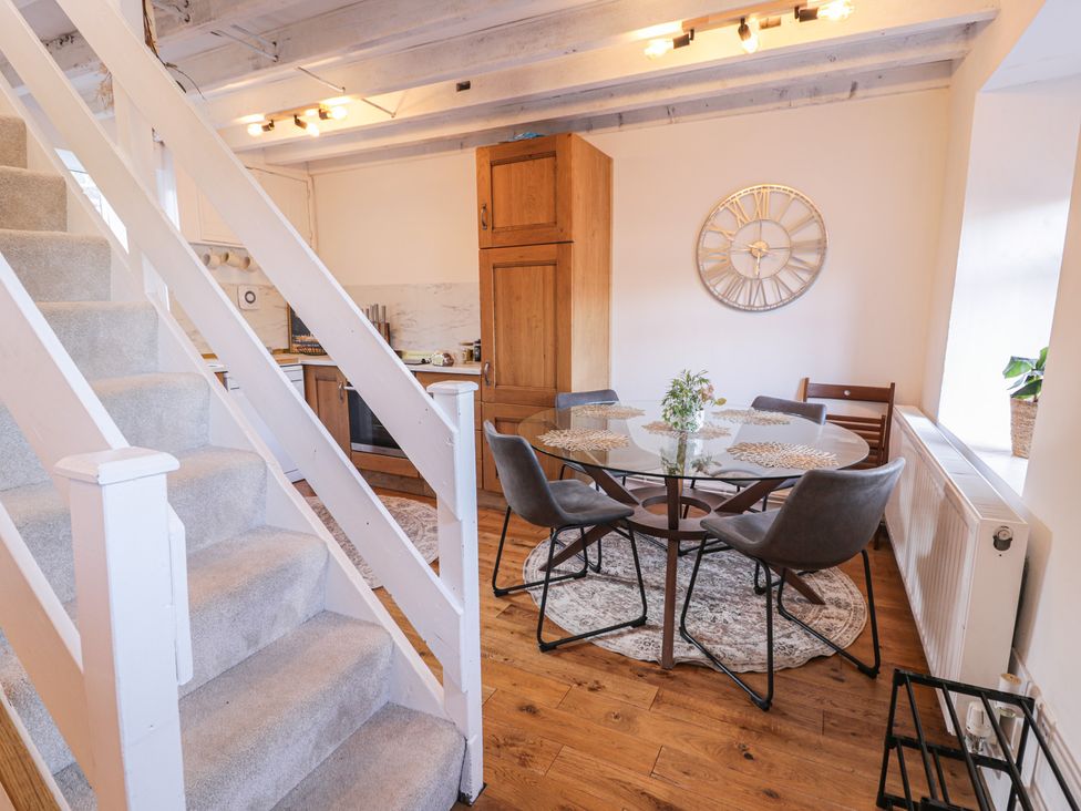 A dining room with a table and chairs at Lon Popty Dolgellau
