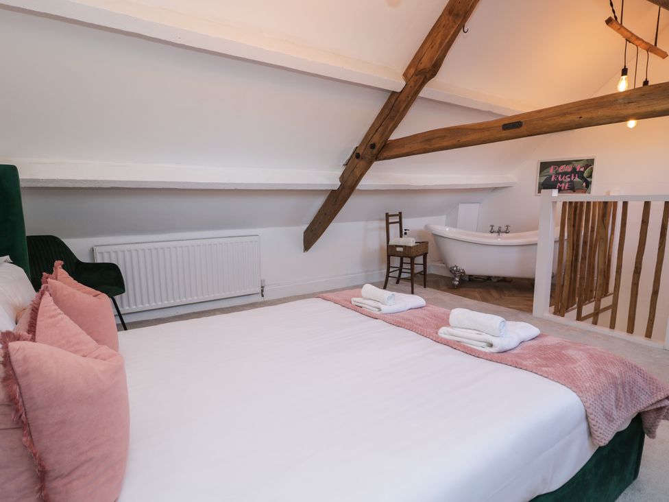 A bedroom with a bed and bathtub at Lon Popty in Dolgellau