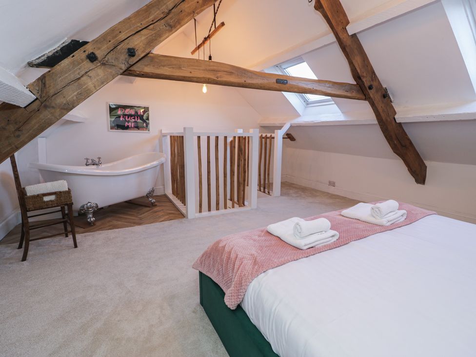 A bedroom with a bed and bathtub at Lon Popty in Dolgellau