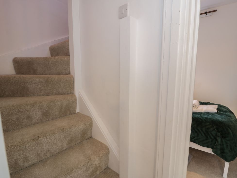 Stairs leading to a room with a bed at Lon Popty in Dolgellau