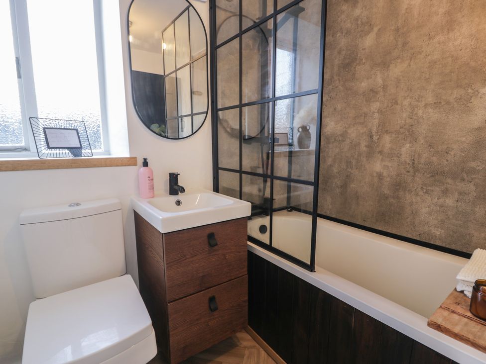 A bathroom with a toilet and bathtub at Lon Popty in Dolgellau