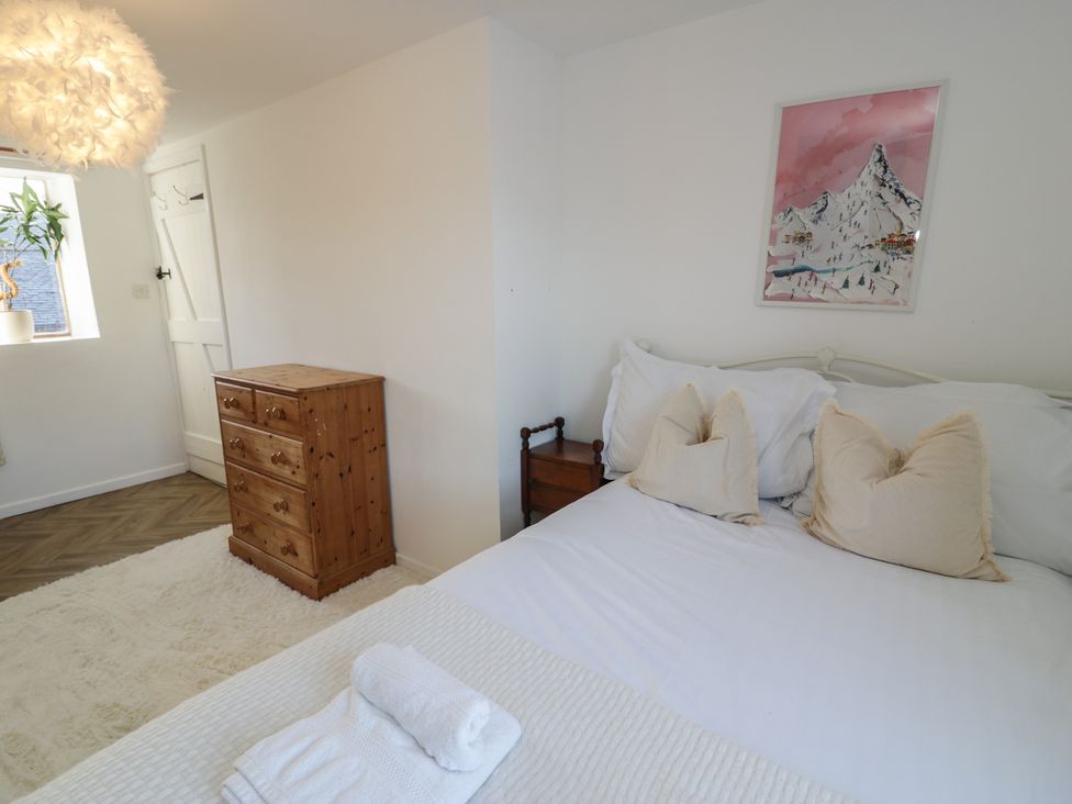 A bedroom with a bed and artwork at Lon Popty in Dolgellau