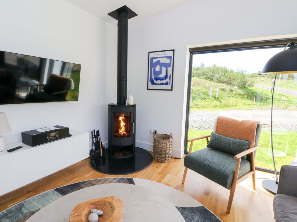 A living room with a wood stove and armchair at Strathview