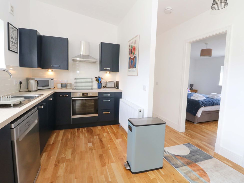 A kitchen with appliances and a view into another room at Strathview