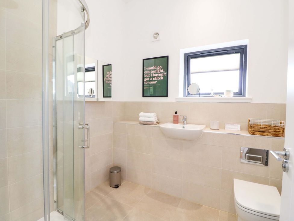 A bathroom with shower, sink, and mirror at Strathview
