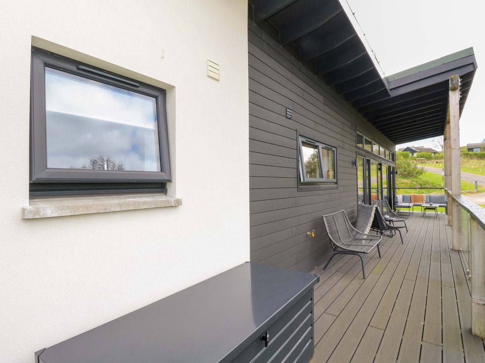 A patio area with chairs and a storage unit at Strathview