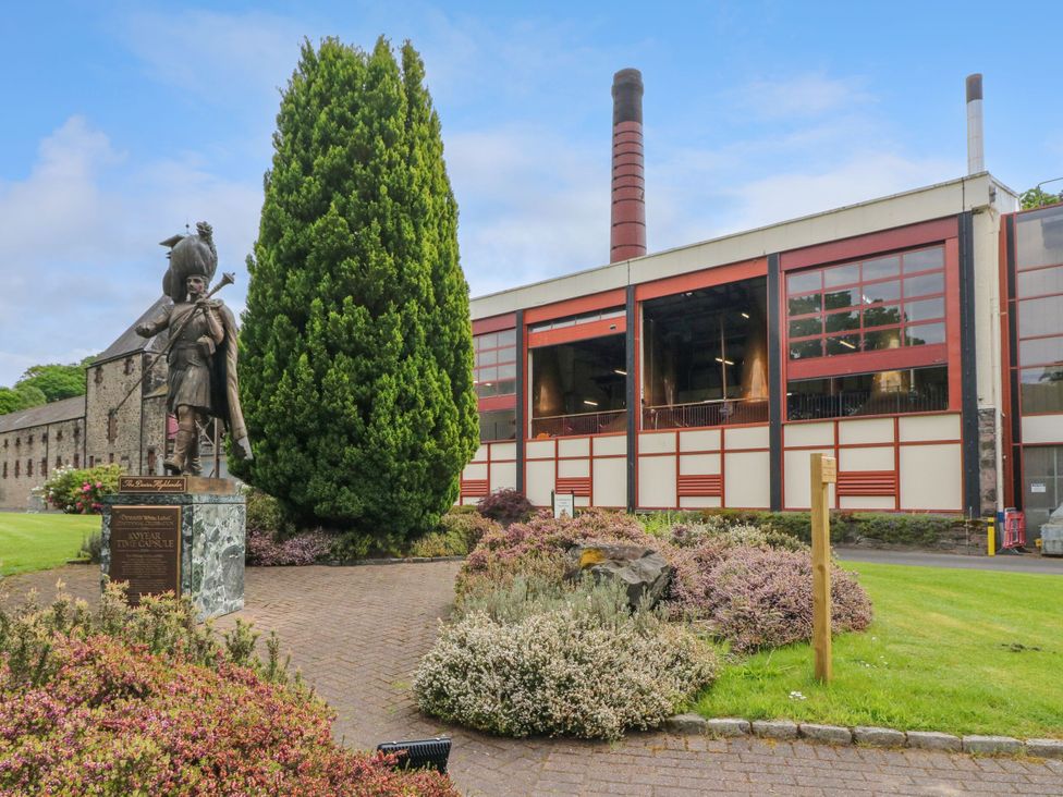 An outdoor area with a statue, tree, and building at Strathview 