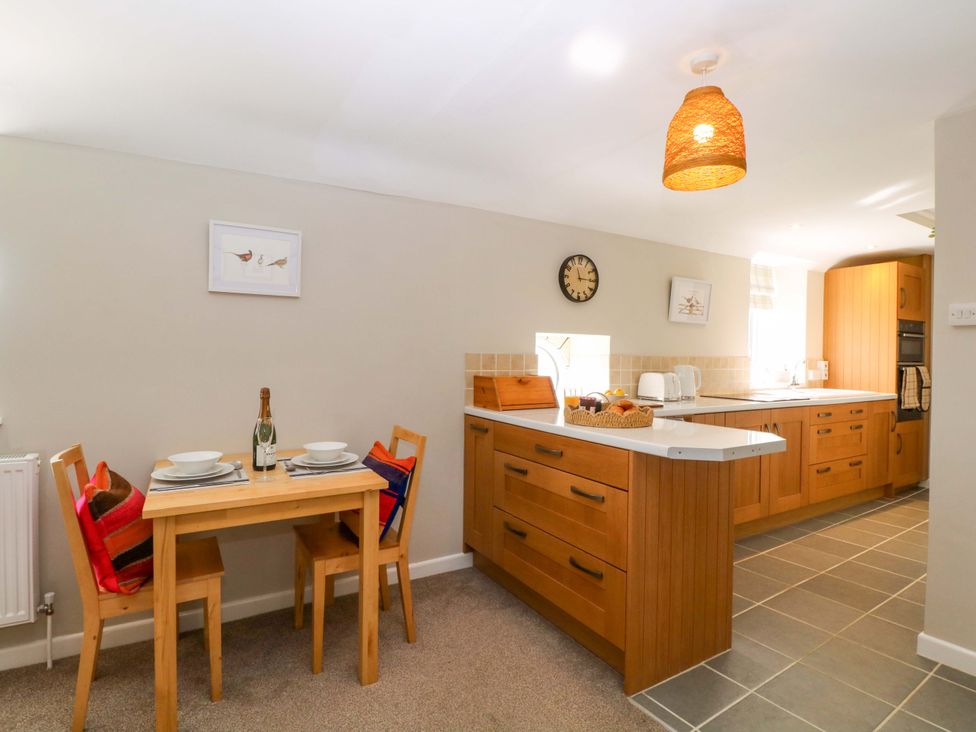 A kitchen with a dining table and chairs at Farm View Annex in Painswick