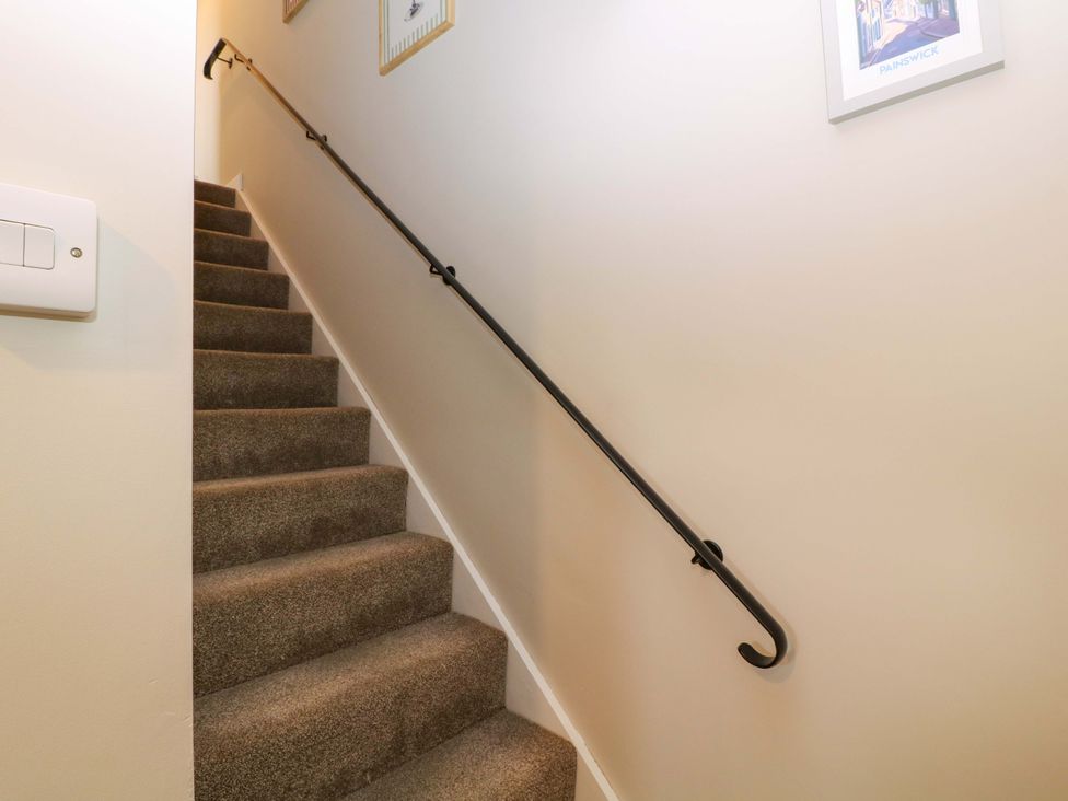 A staircase with a handrail and light switch at Farm View Annex in Painswick