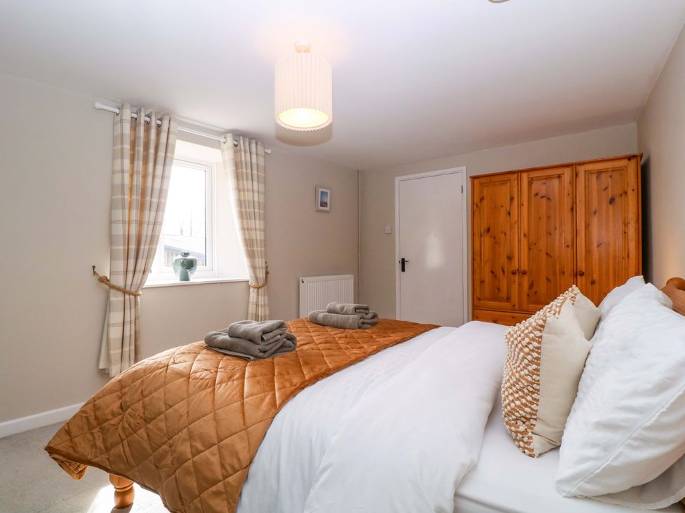 A bedroom with a bed and wardrobe at Farm View Annex Painswick