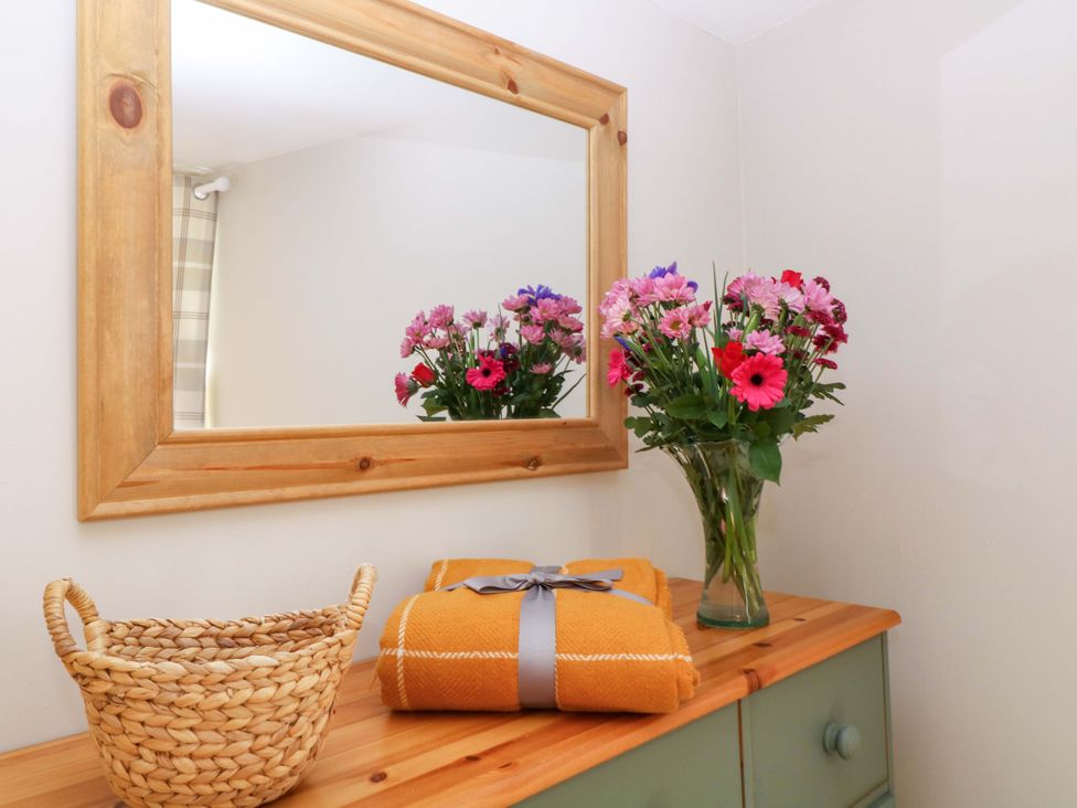 A dresser with flowers and a basket at Farm View Annex, Painswick