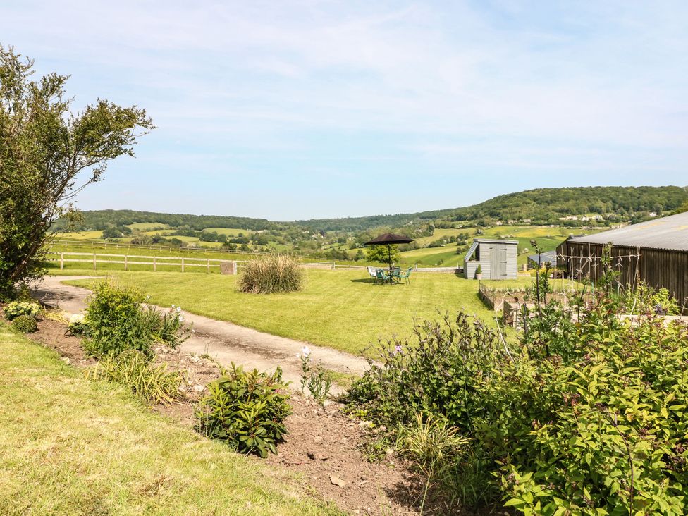 A garden with a table and chairs at Farm View Annex in Painswick