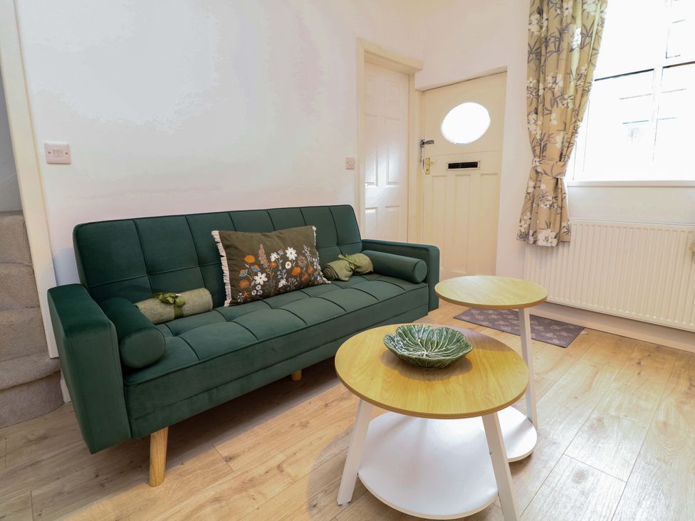 A sitting room with a green sofa and two coffee tables at 14 Crown terrace Belper