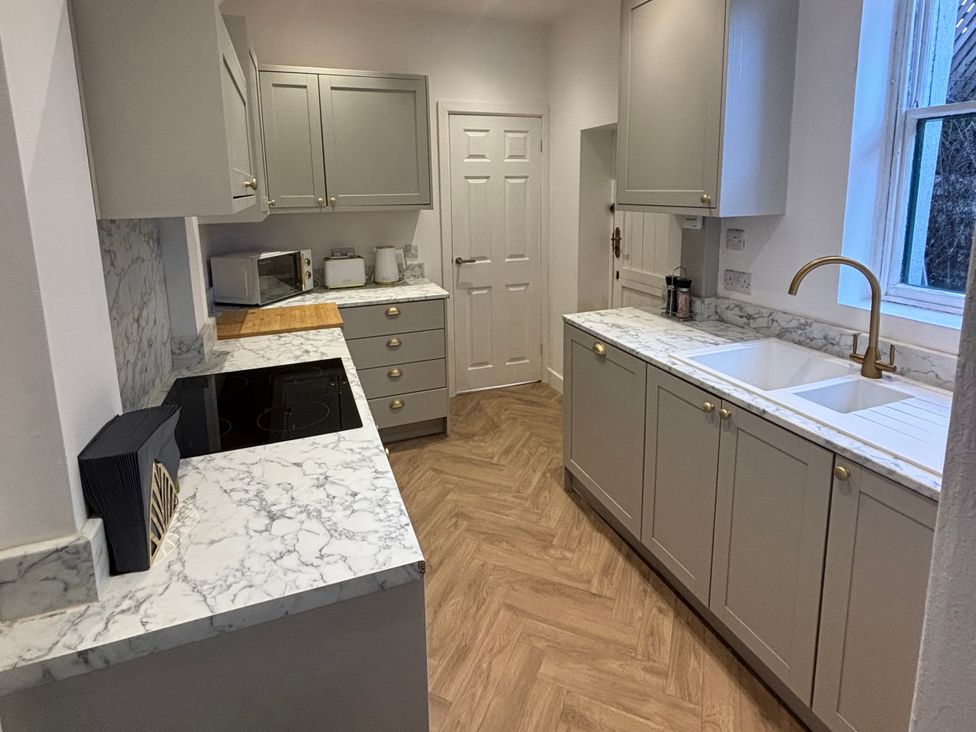 A kitchen with countertop and appliances at Crown Cottage in Belper