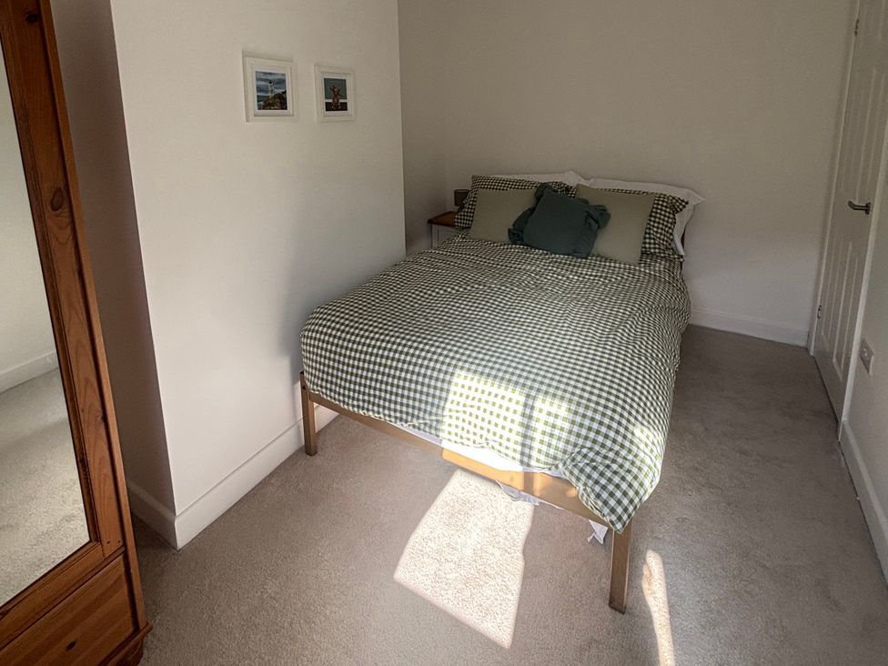 A bedroom with a bed and mirrors at Crown Cottage in Belper
