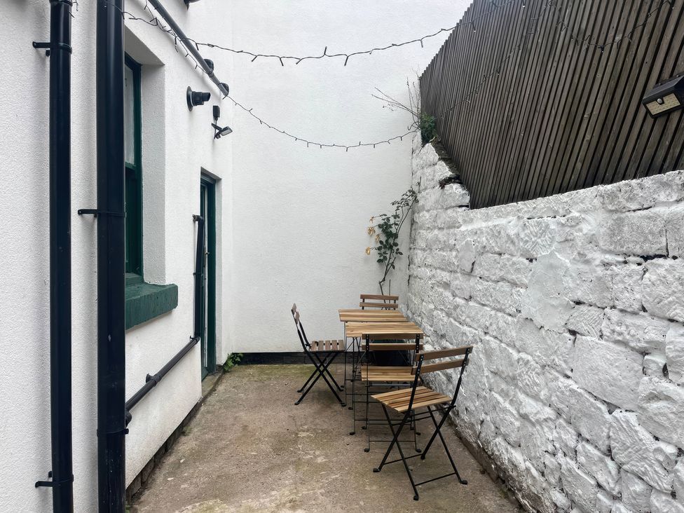 A small outdoor seating area with table and chairs at Crown Cottage in Belper