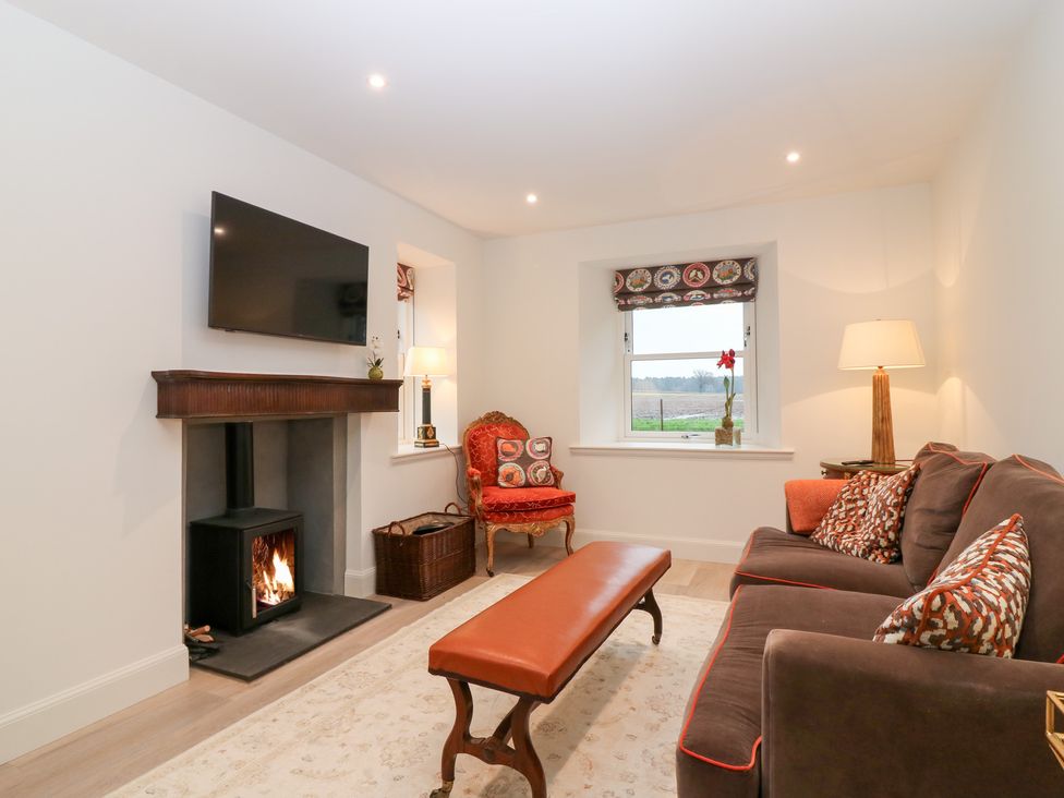 A living room with a fireplace and sofa at 4 East Camno Farm Cottages Near Meigle