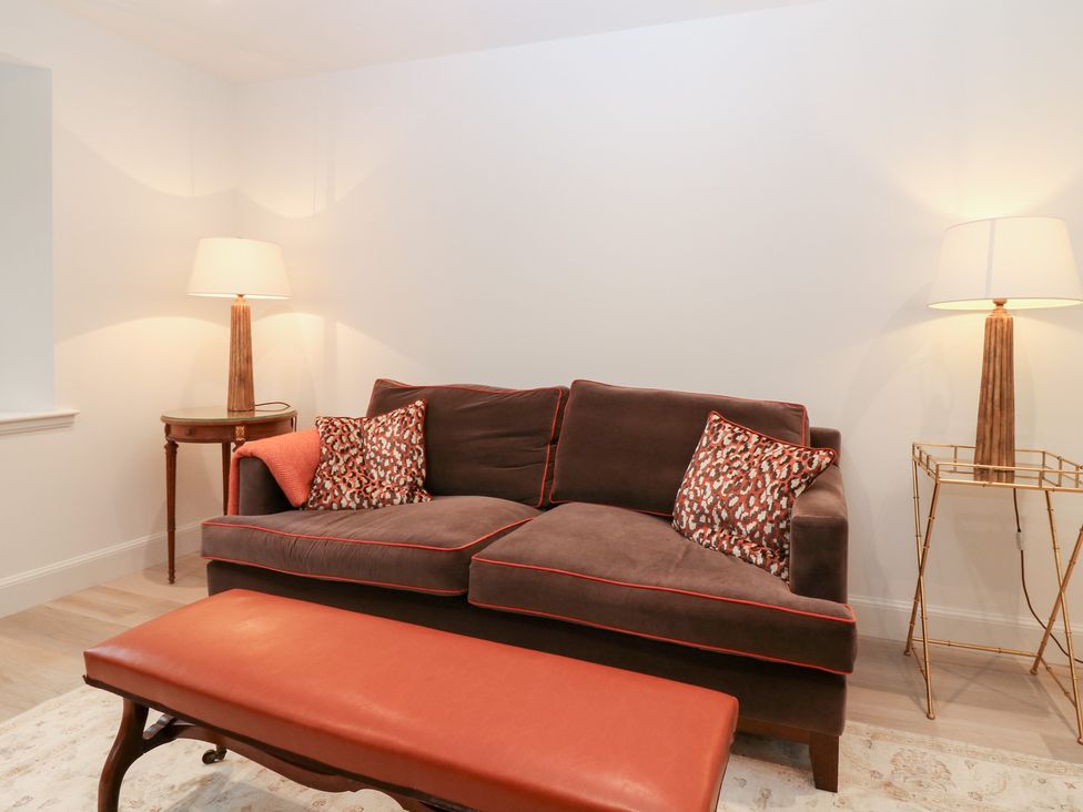 A living room with a sofa and lamp at 4 East Camno Farm Cottages near Meigle