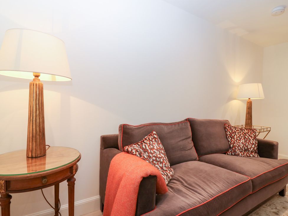 A living room with a sofa and lamp at 4 East Camno Farm Cottages near Meigle