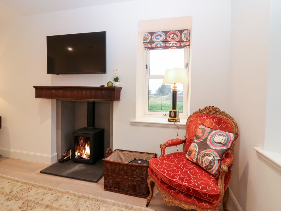 A living room with a fireplace and seating area at 4 East Camno Farm Cottages Near Meigle