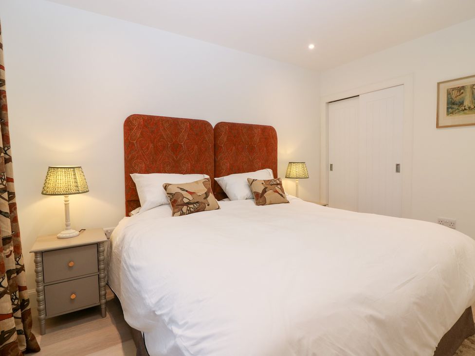 A bedroom with a double bed and bedside lamps at 4 East Camno Farm Cottages near Meigle
