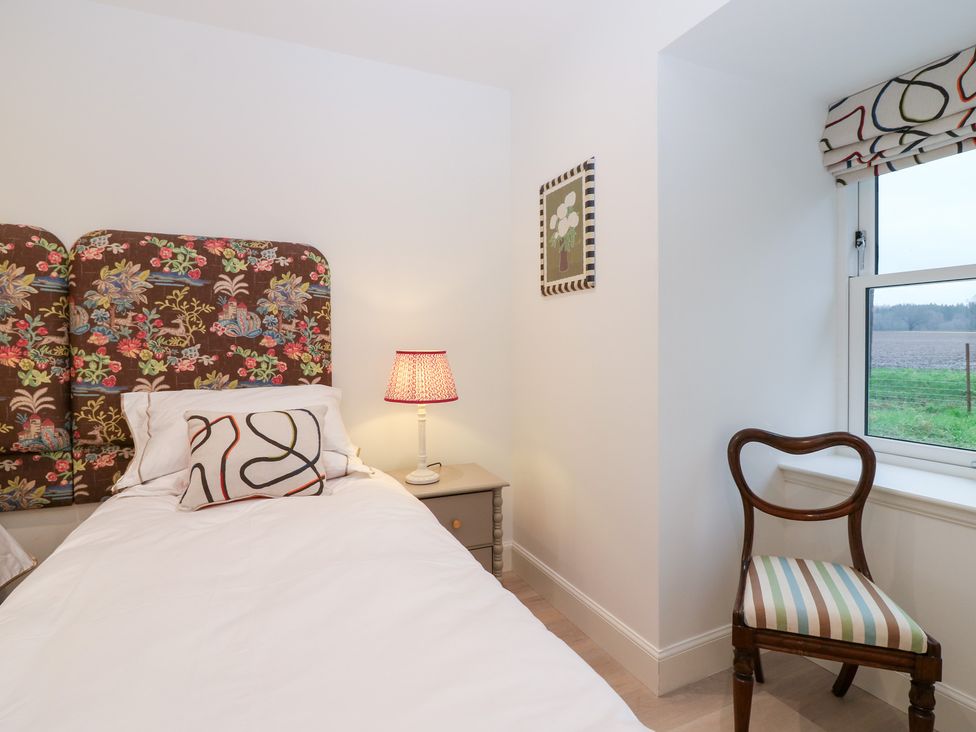 A bedroom with a bed and lamp at 4 East Camno Farm Cottages Near Meigle