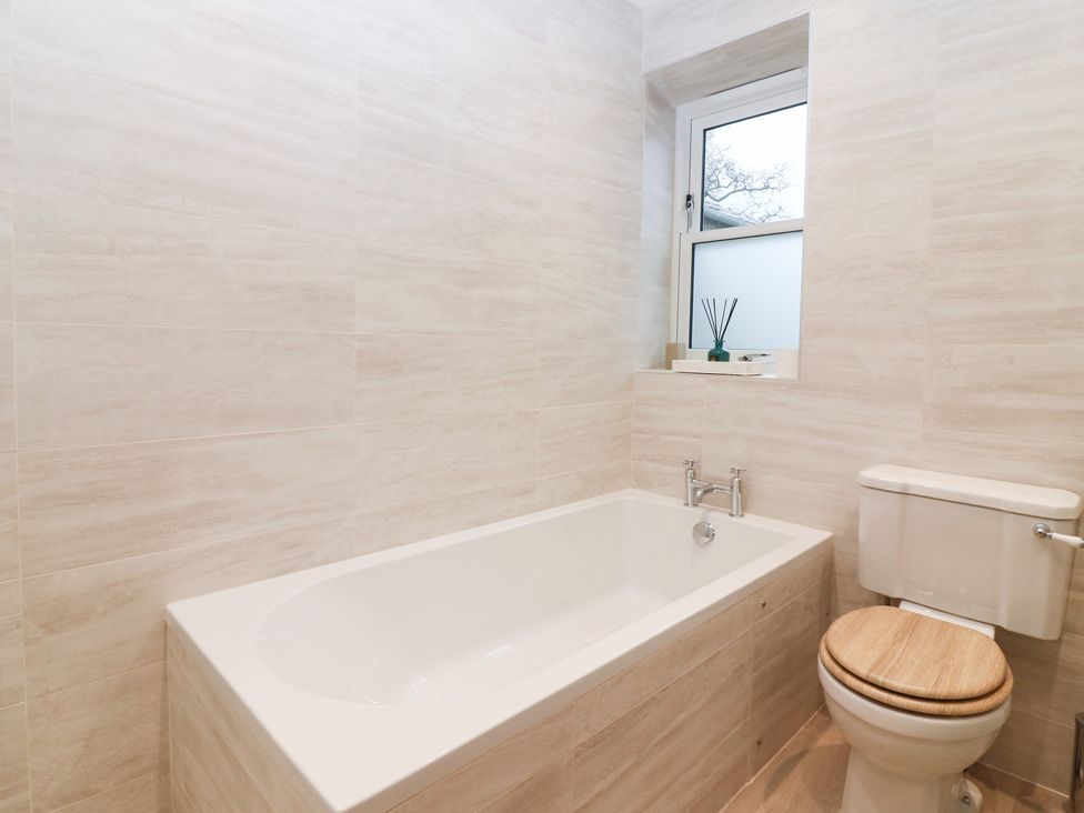 A bathroom with a bathtub and toilet at 4 East Camno Farm Cottages Near Meigle