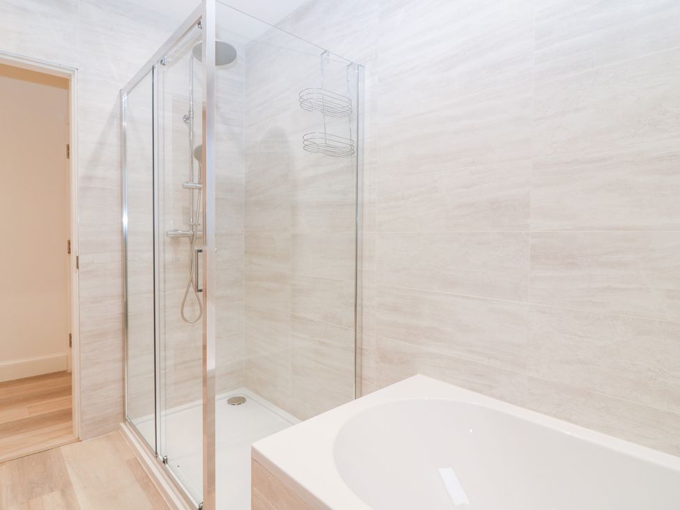 A bathroom with a shower and bathtub at 4 East Camno Farm Cottages near Meigle