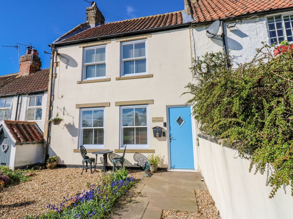 An outdoor area with a blue door and seating at 27 West Green 