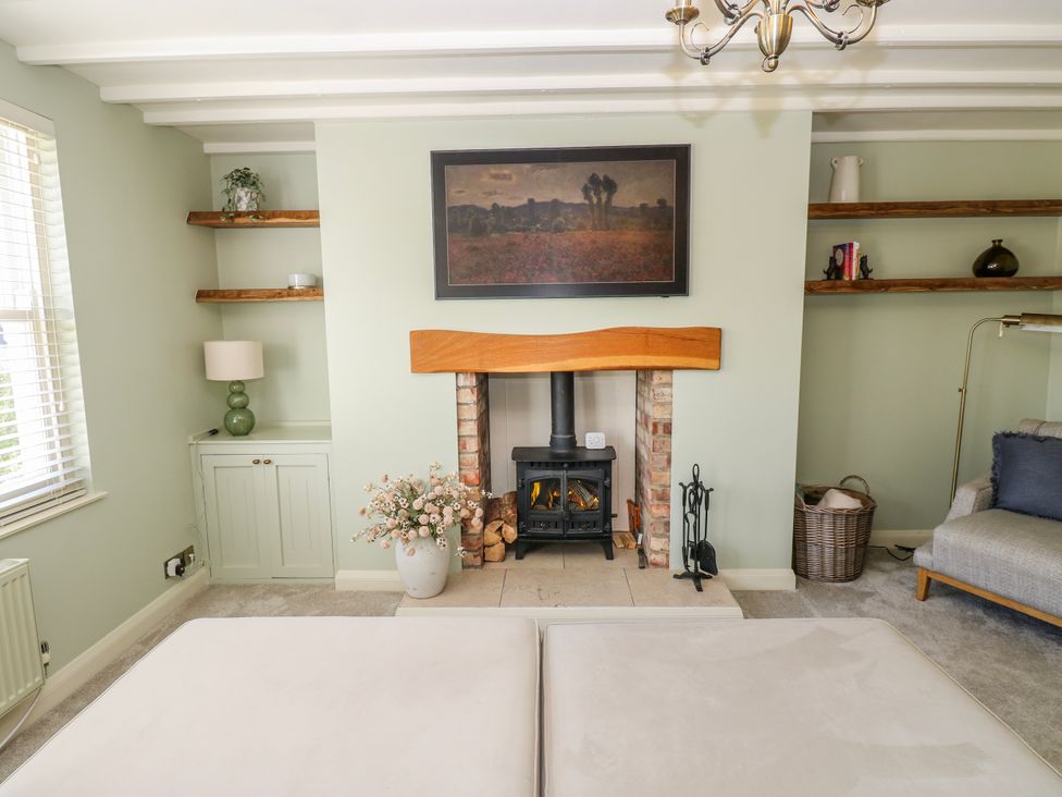 A living room with a fireplace and shelving at 27 West Green