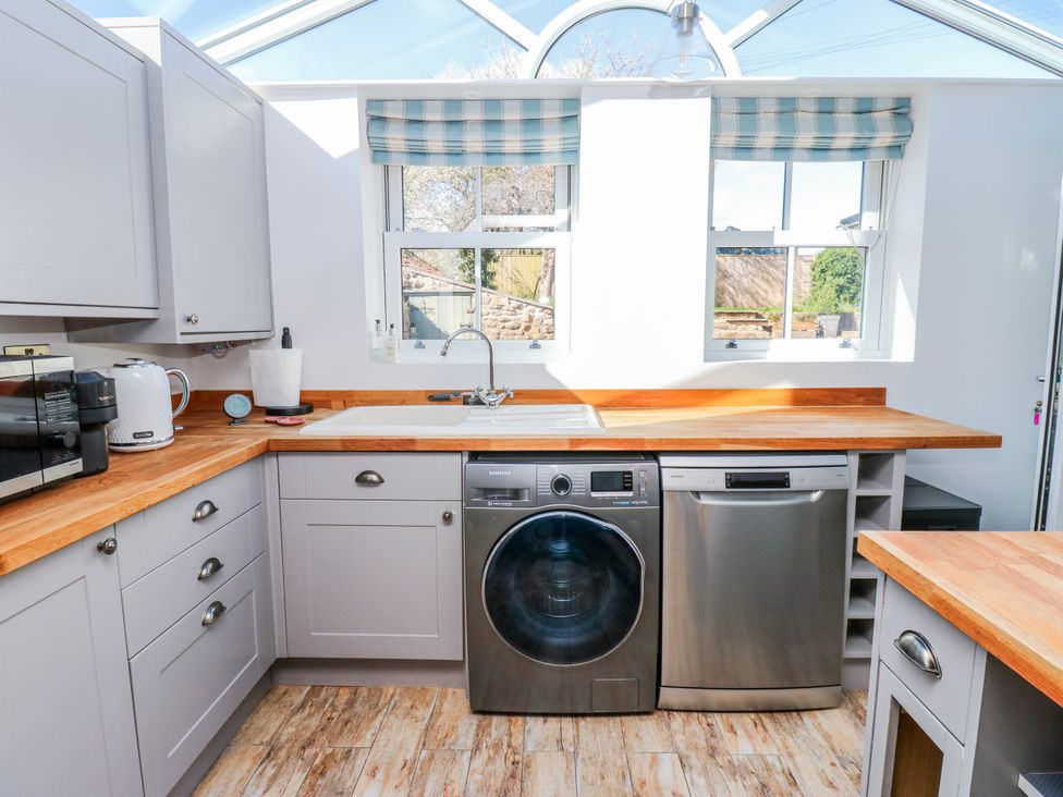 A kitchen with appliances including a washer and dishwasher at 27 West Green